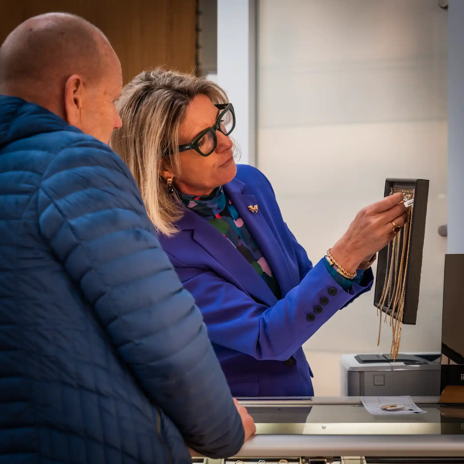 Medewerker bespreekt goud verkoop met klant aan toonbank Amsterdam