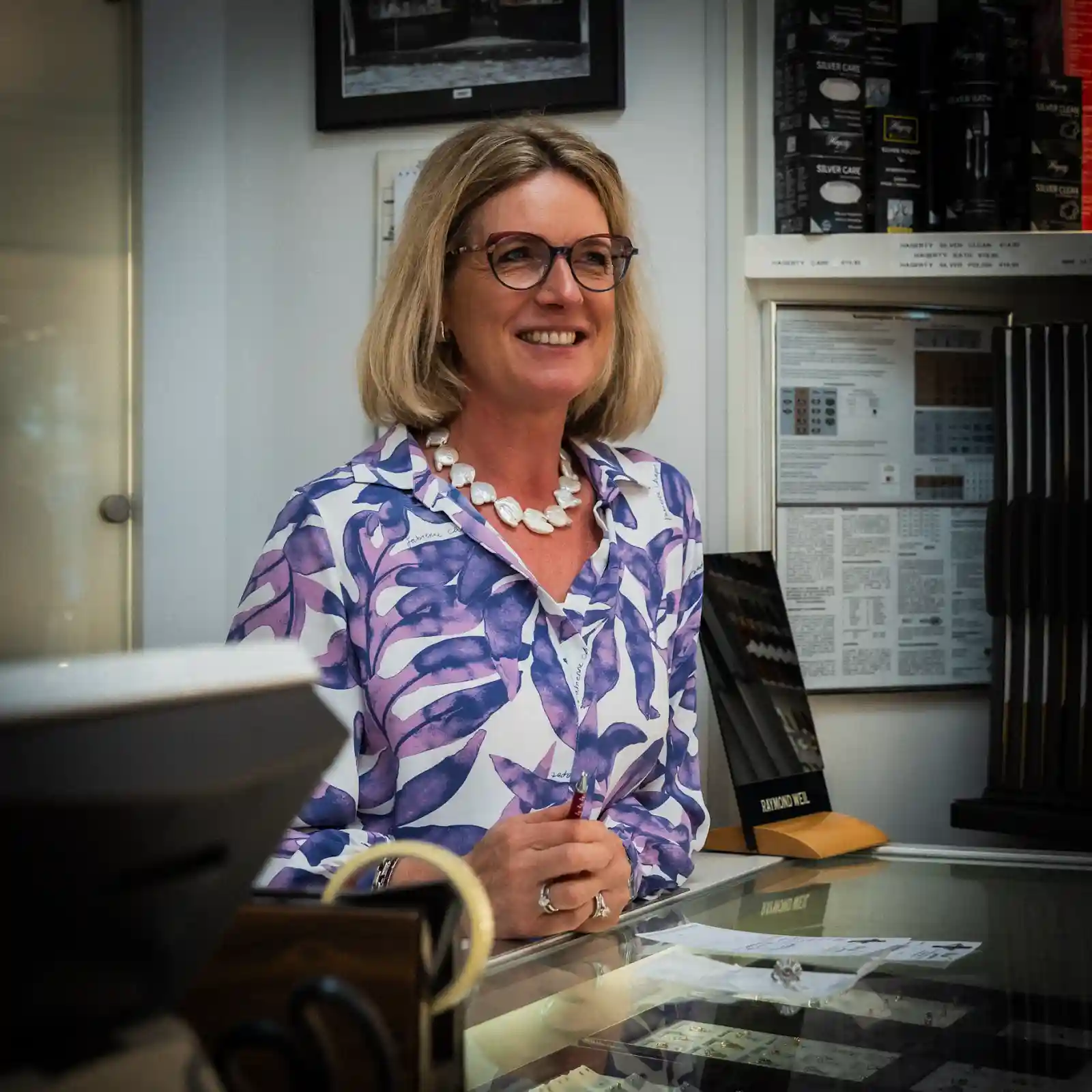 Medewerker geeft persoonlijk advies aan de toonbank in de juwelierswinkel