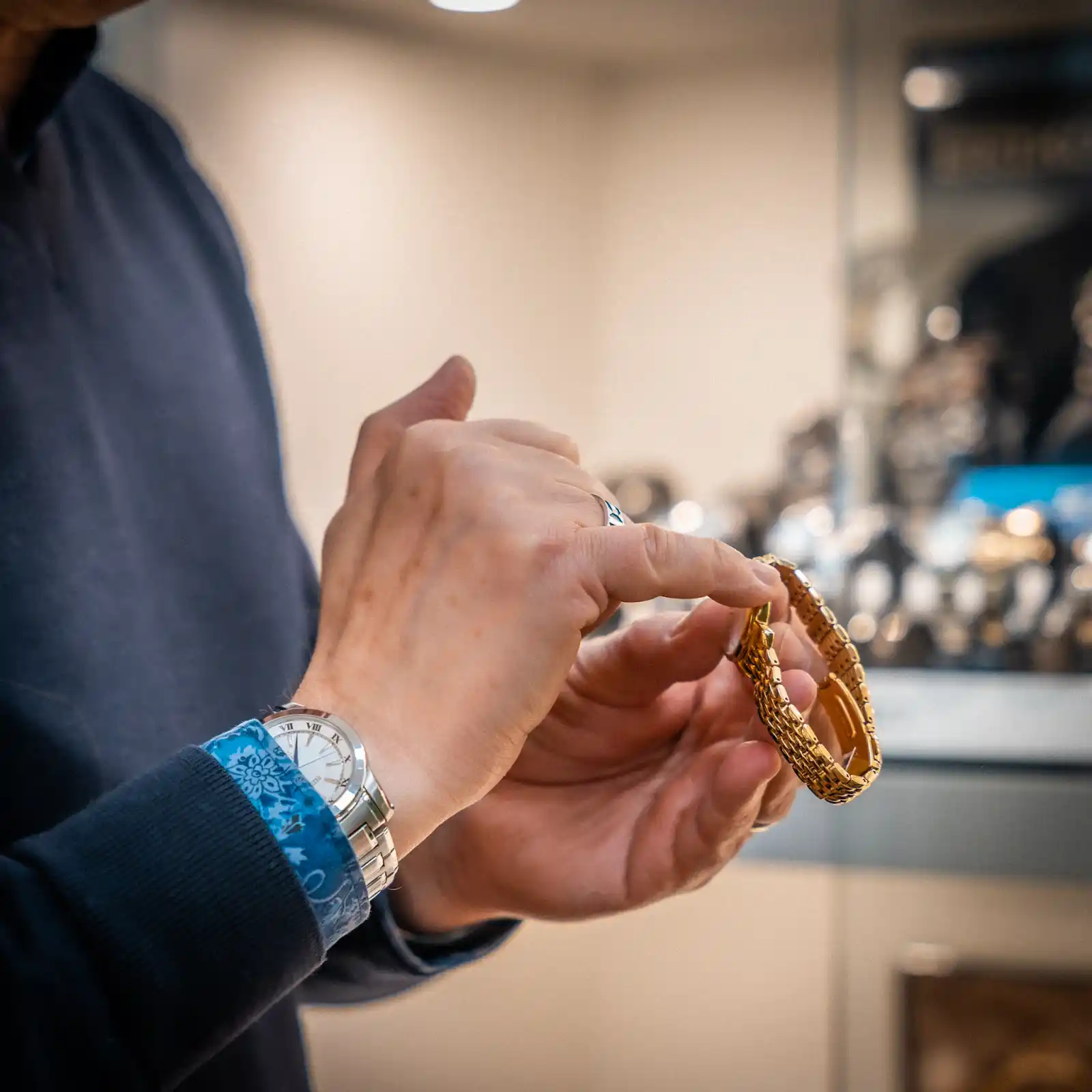 Handen beoordelen gouden armband tijdens waardebepaling in juwelierszaak