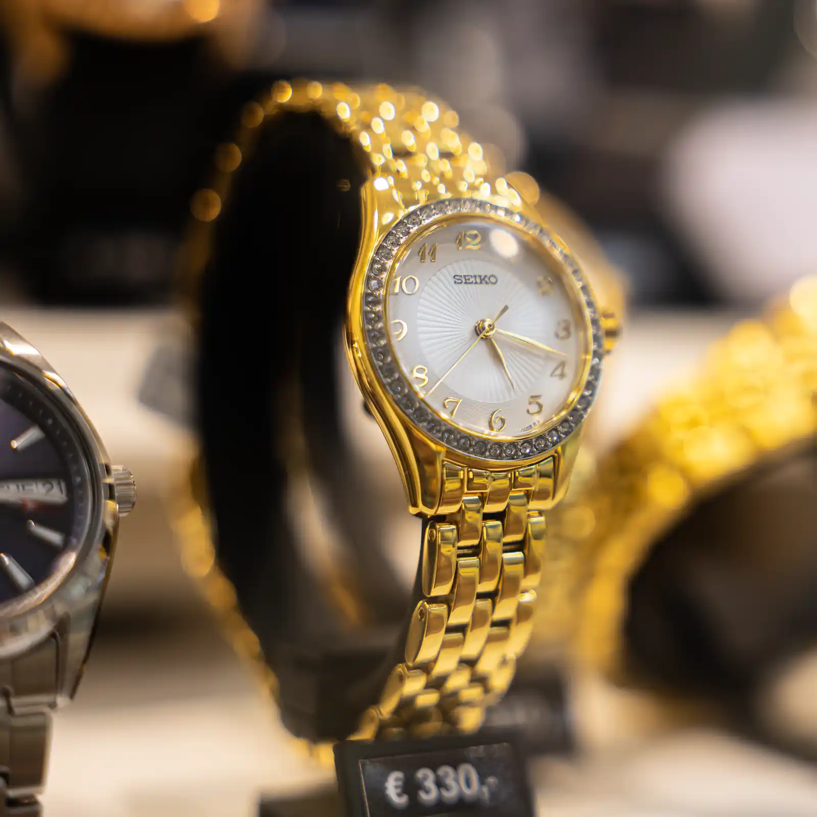 Gouden polshorloge ligt uitgestald als sierlijk accessoire in winkelvitrine in Amsterdam